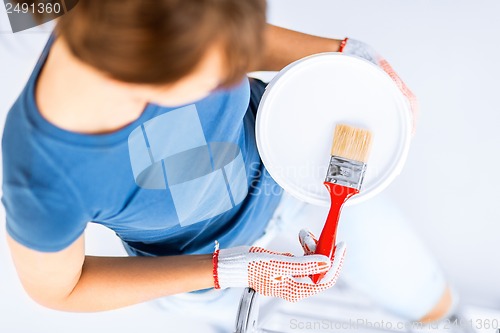 Image of woman with paintbrush and paint pot