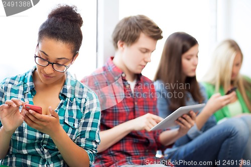 Image of students looking into devices at school