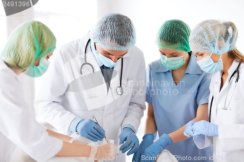 Image of young group of doctors doing operation