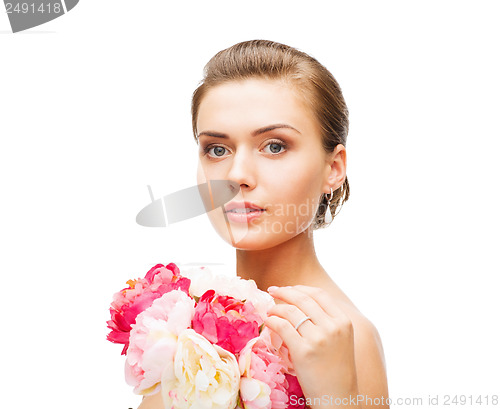 Image of woman wearing earrings and ring with flowers