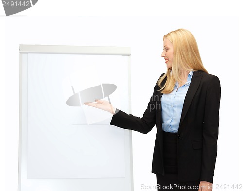 Image of businesswoman pointing at white blank flipchart