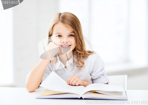 Image of little student girl studying at school