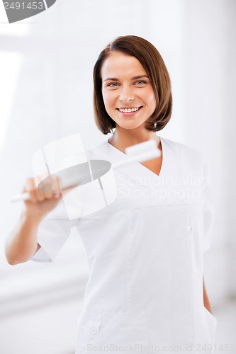 Image of dentist with toothbrush in hospital