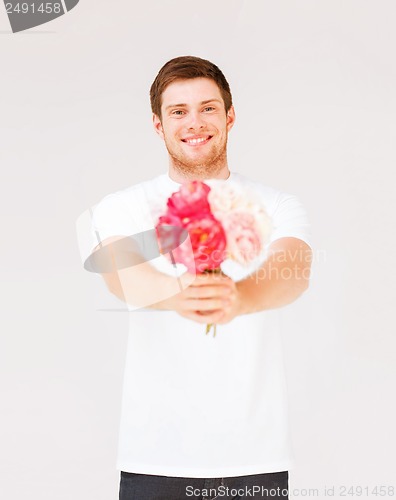 Image of young man holding bouquet of flowers