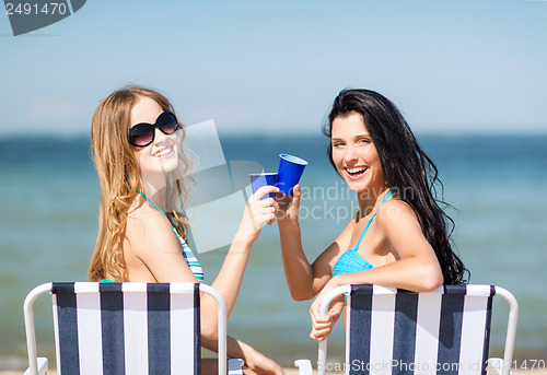 Image of girls with drinks on the beach chairs