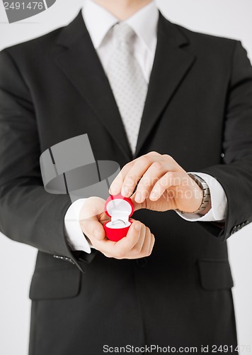 Image of man with gift box and wedding ring