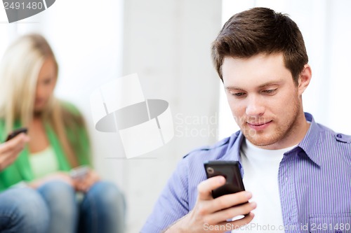 Image of student looking at phone and tiping