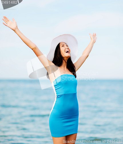 Image of girl with hands up on the beach