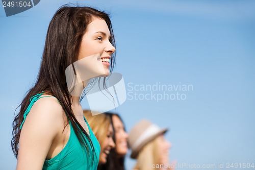 Image of girl with friends walking on the beach