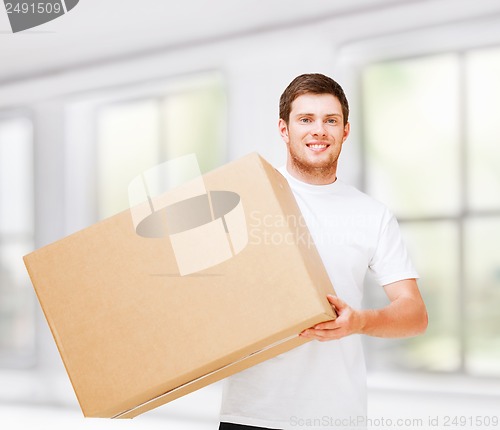 Image of smiling man carrying carton box