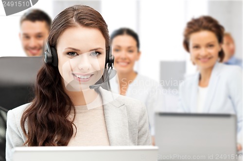 Image of helpline operator with headphones in call centre