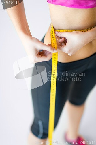 Image of trained belly with measuring tape