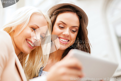 Image of beautiful girls toursits looking into tablet pc