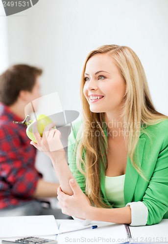 Image of student girl with green apple in college