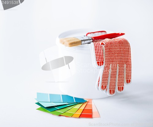 Image of paintbrush, paint pot, gloves and pantone samplers