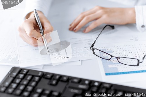 Image of woman hand filling in invoice paper