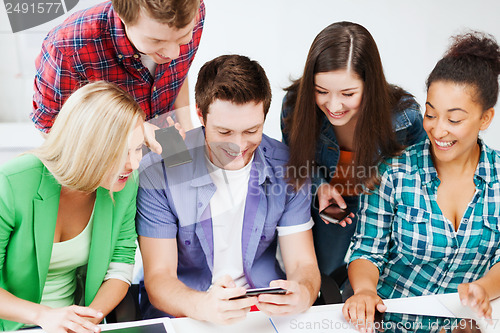 Image of students looking into smartphone at school