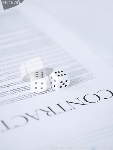 Image of contract paper with gambling dices