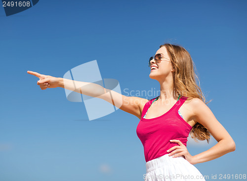 Image of girl showing direction on the beach