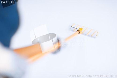 Image of woman with roller and paint colouring the wall