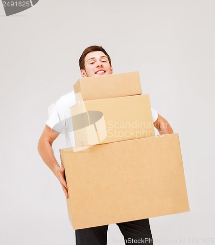 Image of young man carrying carton boxes