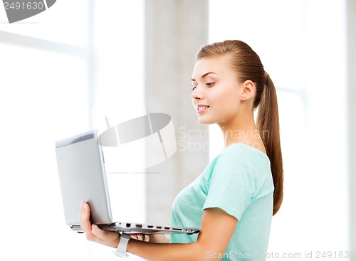 Image of smiling student girl with laptop at school