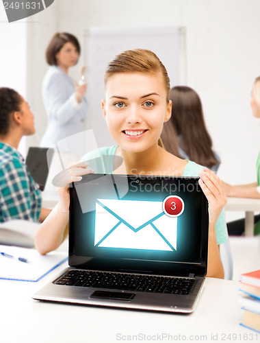 Image of girl holding laptop with email sign at school