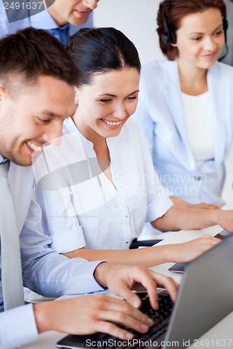 Image of group of people working with laptops in office