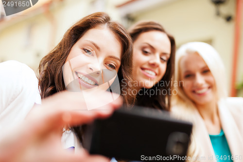 Image of beautiful girls taking picture in cafe in city