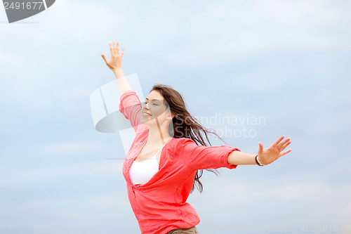 Image of girl with hands up on the beach