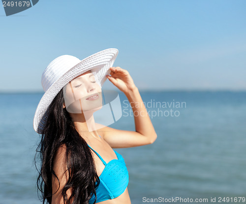Image of girl in bikini standing on the beach