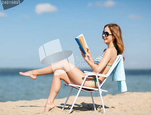 Image of girl reading book on the beach chair