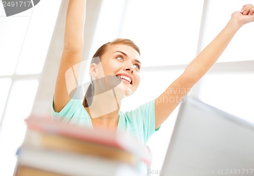 Image of happy student girl with computer at school