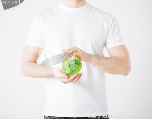 Image of man hands holding green sphere globe