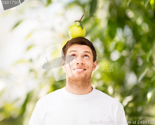 Image of man with green apple on his head