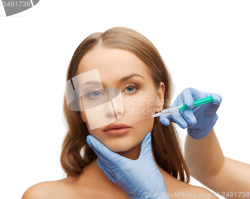 Image of woman face and beautician hands with syringe