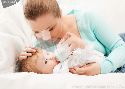 Image of mother and adorable baby with feeding-bottle