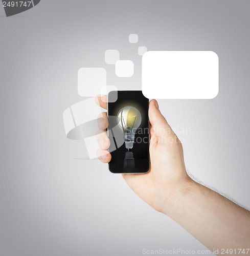 Image of man hand holding smartphone with light bulb