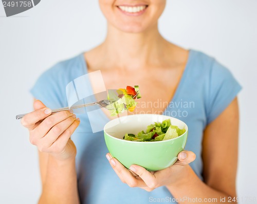 Image of woman eating salad with vegetables