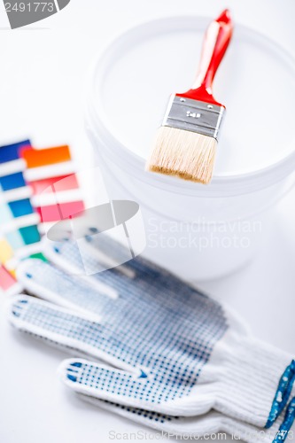 Image of paintbrush, paint pot, gloves and pantone samples