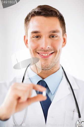 Image of young male doctor offering pill