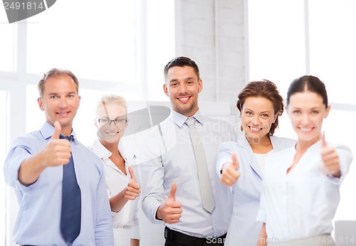 Image of business team showing thumbs up in office