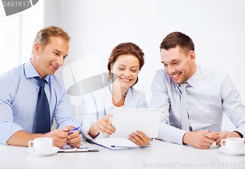Image of business team looking at tablet pc in office