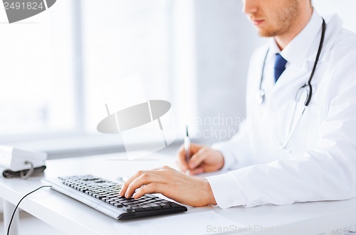 Image of male doctor typing  on the keyboard