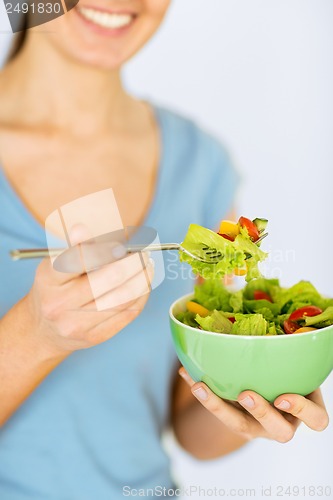 Image of woman eating salad with vegetables