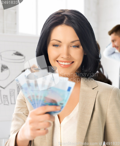 Image of happy businesswoman with cash money in office