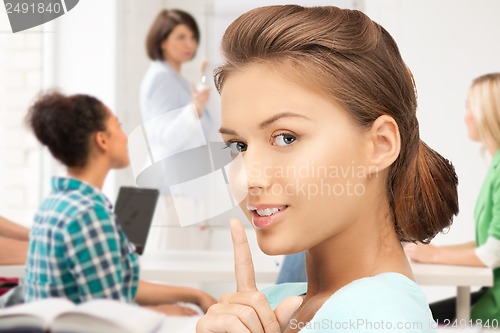 Image of student making hush gesture at school