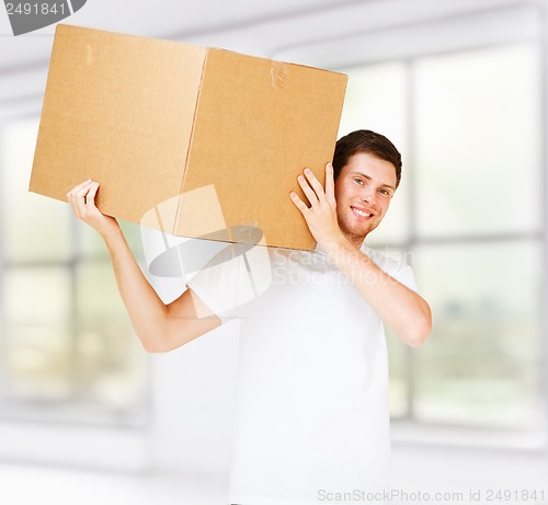 Image of smiling man carrying carton box
