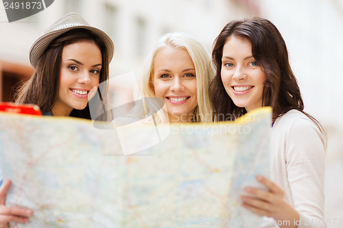 Image of beautiful girls looking into tourist map in city