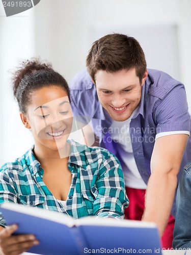 Image of students reading book at school
